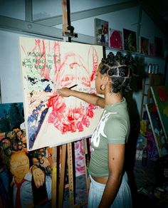 a woman is painting in an art studio