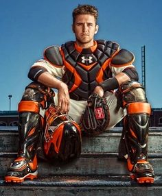 a baseball player sitting on the ground wearing catchers gear