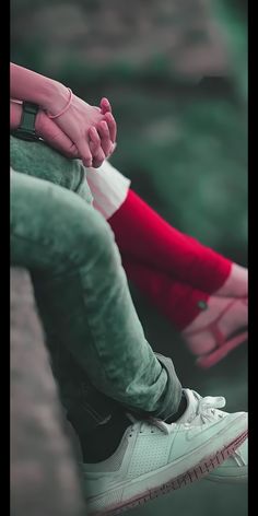 a person sitting on a bench with their legs crossed, wearing red and white socks