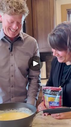 a man and woman are cooking in the kitchen with ingredients on the counter next to them