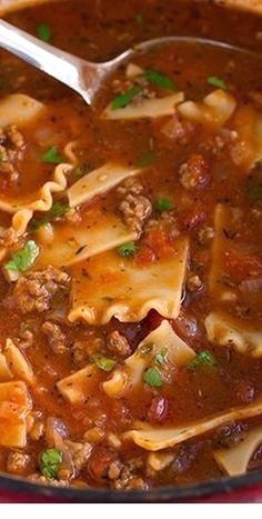 a red pot filled with pasta and meat soup