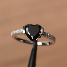 It is a natural black spinel ring. The main stone is 8mm*8mm heart cut, weight about 2.33 carats. The basic metal is sterling silver and plated with rhodium. To change the metal to a solid gold (white/rose) or platinum is also available, please ask for a quotation if you want. You can also go to my shop Home for more elegant rings: https://www.etsy.com/shop/godjewelry?ref=hdr_shop_menu More black spinel rings: https://www.etsy.com/shop/godjewelry/items?ref=seller-platform-mcnav&section_id=21 Black Heart Cut Jewelry For Wedding, Black Heart-shaped Jewelry For Anniversary, Black Heart Cut Rings For Valentine's Day, Sterling Silver Heart Cut Jewelry For Proposal, Elegant Black Heart Cut Rings, Black Heart Cut Heart Ring As Gift, Black Heart Cut Ring For Gift, Black Heart-shaped Gemstone Jewelry, Black Heart-shaped Promise Jewelry