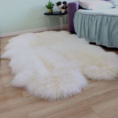 a white sheepskin rug on the floor in a bedroom