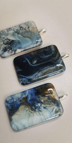 three rectangular glass pendants sitting on top of a table