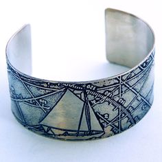 All you need is a tall ship, a star to steer it by, and this nautical cuff! If you love sailing, or know someone who does, this is the perfect gift! This cuff bracelet is formed from 18 gauge nickel silver, copper, or brass that measures 1 1/4" wide. It is etched with an original graphic illustration of a sailboat and chart, then polished and finished with a blue patina. The medium sized cuff is 6" long with a gap of a little over 1" and will fit most wrists. It can be gently adjusted by bending Artsy Gift, Peacock Colors, Peacock Wedding, Nautical Art, Memphis Tn, Silver Art, Nickel Silver, Peacock Feather, Anniversary Wedding