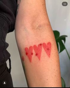 a person with a tattoo on their arm that has hearts and stars painted on it