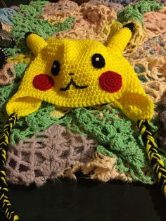 a crocheted pikachu hat laying on top of a blanket