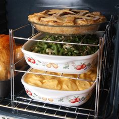 an oven filled with different types of food in dishes and pies on trays