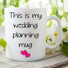 this is my wedding planning mug on a table with white flowers and greenery in the background