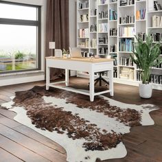 a living room filled with furniture and a cowhide rug on top of a hard wood floor