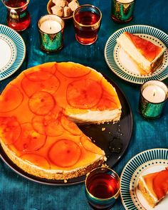 there is a pie on the table with many plates next to it and cups around it