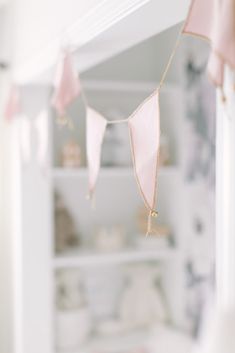 a baby crib with pink and gold decorations hanging from it's sides,