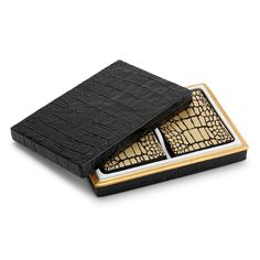 two black alligator skin wallets with gold accents on the front and back, sitting on top of each other