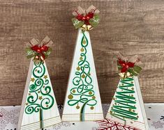 three wooden christmas trees with bows on them