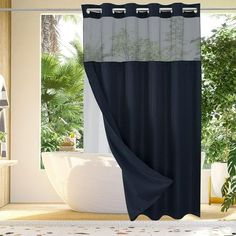 a bathroom with a bathtub, shower curtain and potted plants on the floor