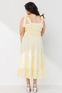 Our exquisite Plus Size Yellow Tiered Dress stunningly redefines the art of dressing with its intricately designed tiered style and contemporary square neckline. The Plus Size Yellow Tiered dress midi-length is skillfully prepared with a smocked bodice and tied shoulder straps that beautifully accentuate your silhouette, while granting superior comfort. This subtly elegant pastel yellow dress, is an ideal outfit for any occasion, promising to imbue you with a radiant confidence and fashionable sophistication all day long. Solid Should Tie Point Tiered Silhouette Light Fabric Midi Dress Length Square Neckline Smocked Bodice Sleeveless Light Pastel Yellow Length of 44" inches 95% Polyester 5% Spandex Be prepared to sway the onlookers with this must-have stylish addition to your wardrobe. Spring Tiered Midi Dress With Tie Straps, Spring Midi Dress With Tie Straps And Tiered Shape, Spring Midi Dress With Tie Straps And Tiered Design, Square Neck Smocked Bodice Tiered Dress For Brunch, Spring Smocked Midi Dress With Tie Straps, Square Neck Tiered Dress With Smocked Back For Brunch, Summer Sundress With Square Neck And Tiered Design, Sundress With Smocked Bodice And Midi Length, Square Neck Smocked Sundress With Tie Straps