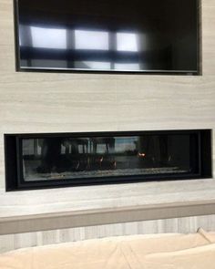 a fireplace with a flat screen tv above it in a room that has no furniture