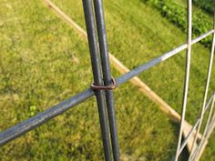 a close up view of an iron fence with grass in the background