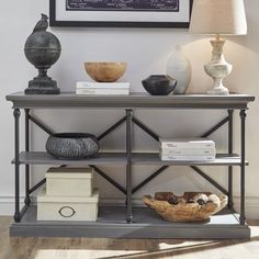 a shelf with books and vases on it in front of a framed chalkboard