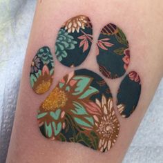 an animal paw with flowers painted on the side of it's arm and leg