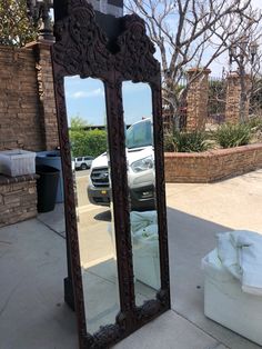 a large mirror sitting on the side of a sidewalk