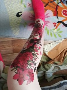 a woman's leg with flowers on it and her legs covered in pink socks