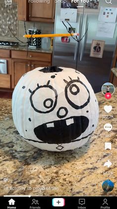 a paper pumpkin with an angry face drawn on it's face, sitting on top of a kitchen counter