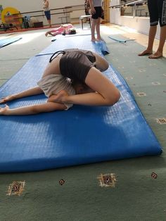 a woman laying on top of a blue mat