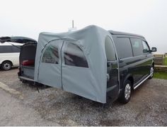 an suv with a tent attached to it parked in a parking lot