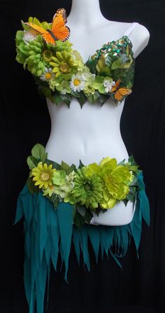 a white mannequin with green and yellow flowers on it's chest, in front of a black background