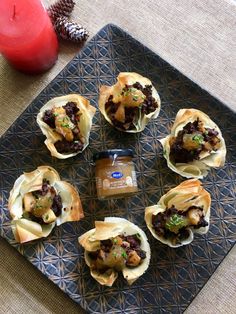 there are many small pastries on the plate with some dipping sauce in front of them