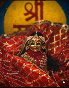 a close up of a person wearing a costume and headdress with a sign in the background