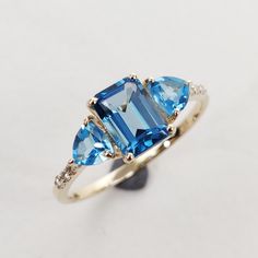 **KINDLY CHECK OUT THE VIDEO OF THE ITEM FOR A CLEARER VIEW**Details of the ring Gemstone: Diamond gem shape & weight: Round, ( 6 piece ) & 0.05 carats London Blue Topaz Octagon 7x5 mm Weight 1.30 carats Swiss Blue Topaz Trillion 4mm (2piece) Weight 0,60 carats Metal: GOLD Purity: 14 KT Weight: 1.11 Grams Total weight of the ring: 1.50 grams Beautiful fine cut Natural Diamond VVS-VS PURITY & I-J color with London, Swiss Blue Topaz set in 14kt Gold ring, a perfect gift for a woman. At Blue Trillion Cut Topaz Ring With Accent Stones, Blue Topaz Trillion Cut Ring, Blue Trillion-cut Topaz Ring, Blue Trillion Cut Topaz Ring, Fine Jewelry Blue Topaz Three Stone Ring, Trillion Cut Blue Topaz Ring With Accent Stones, Trillion Cut Topaz Ring With Accent Stones, 14k Gold Topaz Ring With Gemstone Accents, 14k Gold Topaz Ring With Gemstone Accents For Promise