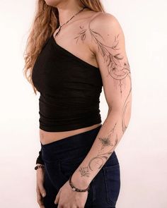 a woman with tattoos on her arm posing for the camera