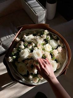 a person holding a bouquet of white roses