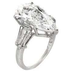 an oval cut diamond ring with baguetts on the shoulders and side stones in white gold