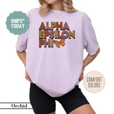 a woman wearing a purple shirt with the words, alpha epson phi on it