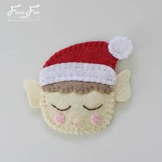 a small felt ornament with a santa hat on it's head and eyes