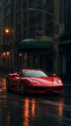 a red sports car parked on the side of a road in the rain at night