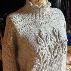 a woman's sweater is on display in a room with other clothing and accessories