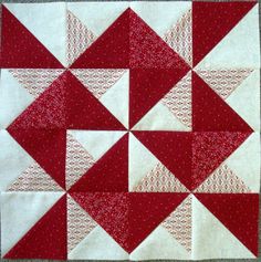 a red and white patchwork quilt with squares on the bottom, one block in the middle