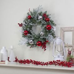 a christmas wreath and other decorations on a mantle