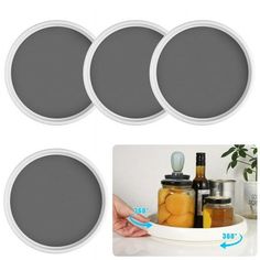 four jars with lids and spoons sitting on a plate next to each other in front of a white background