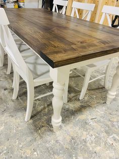 a wooden table with white chairs around it