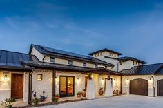 a large house with two garages and lights on