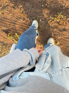 two people are sitting on the ground with their feet in each other's lap