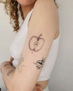 a woman with a tattoo on her arm has an apple and knife in the shape of a heart