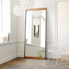 a room with a large mirror, chair and table in the corner next to it