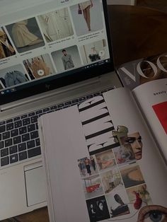 an open book is sitting next to a laptop computer on a wooden table with magazines and eyeglasses