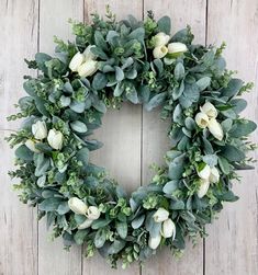 a wreath with white flowers and green leaves